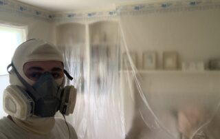 Painter wearing mask took a selfie before interior painting, showcasing items protected with plastic